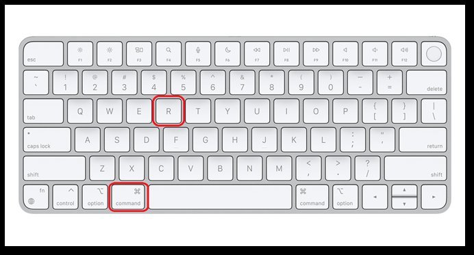 A hand presses the power button on a MacBook Air to initiate recovery mode.