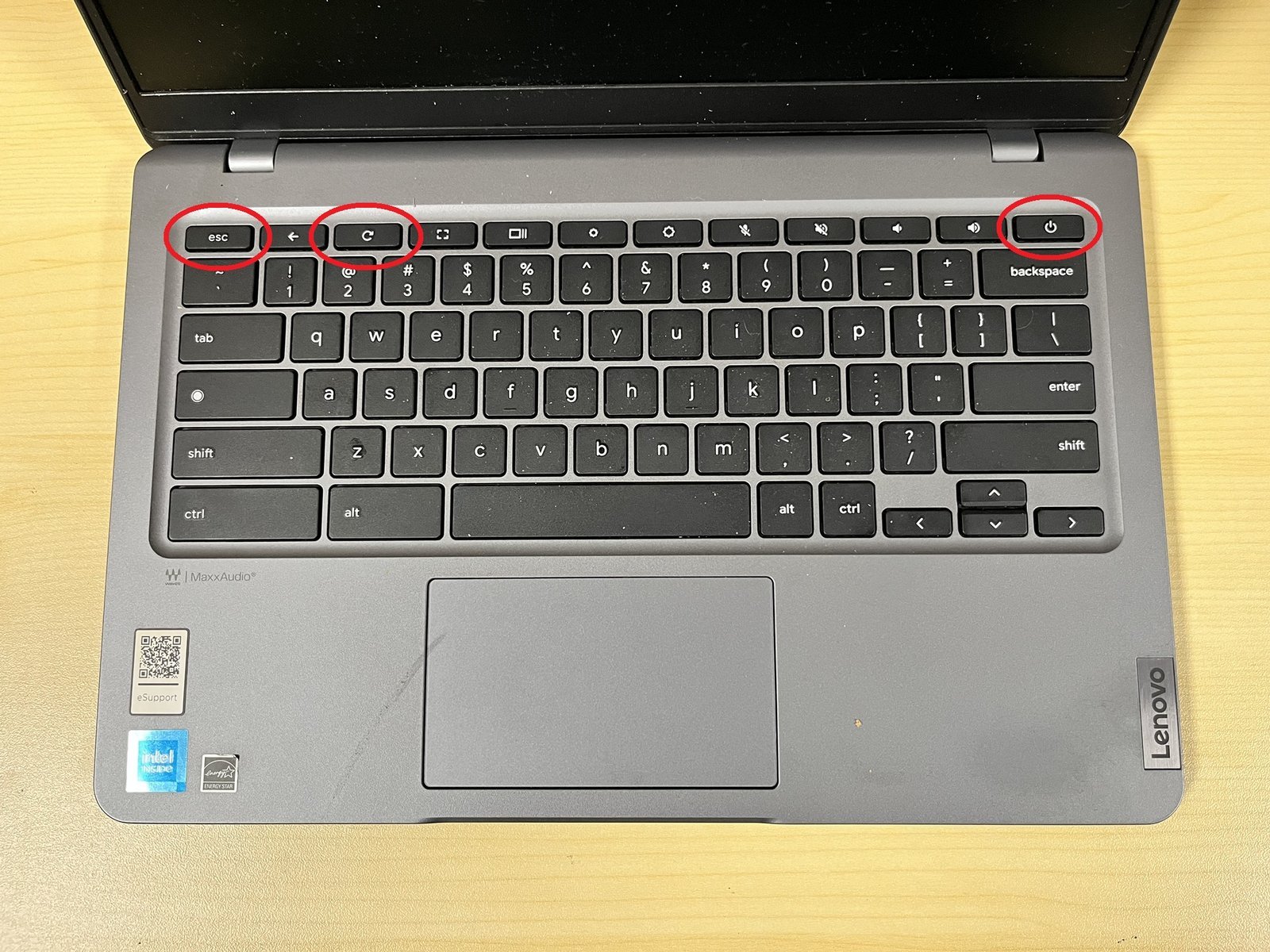 A person troubleshooting a Chromebook using alternative software methods at a desk.