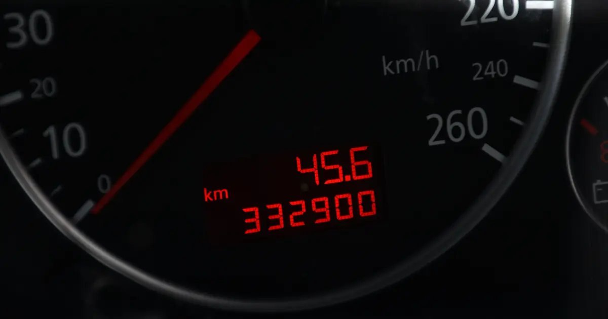 A close-up of a vehicle trip reset pin and key fob on a dashboard.