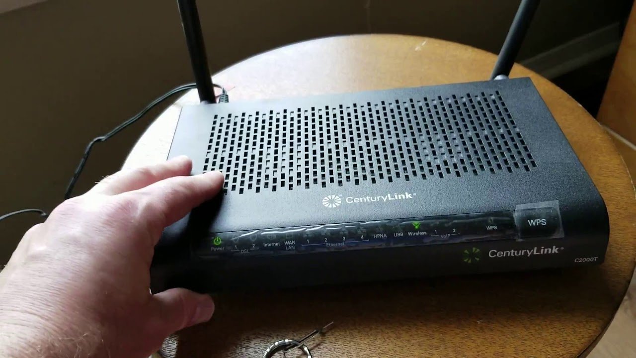 A person uses a laptop to manage router settings for a network restoration.