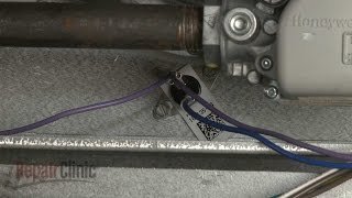 A functioning furnace burner assembly showing controlled blue flames inside the combustion chamber.