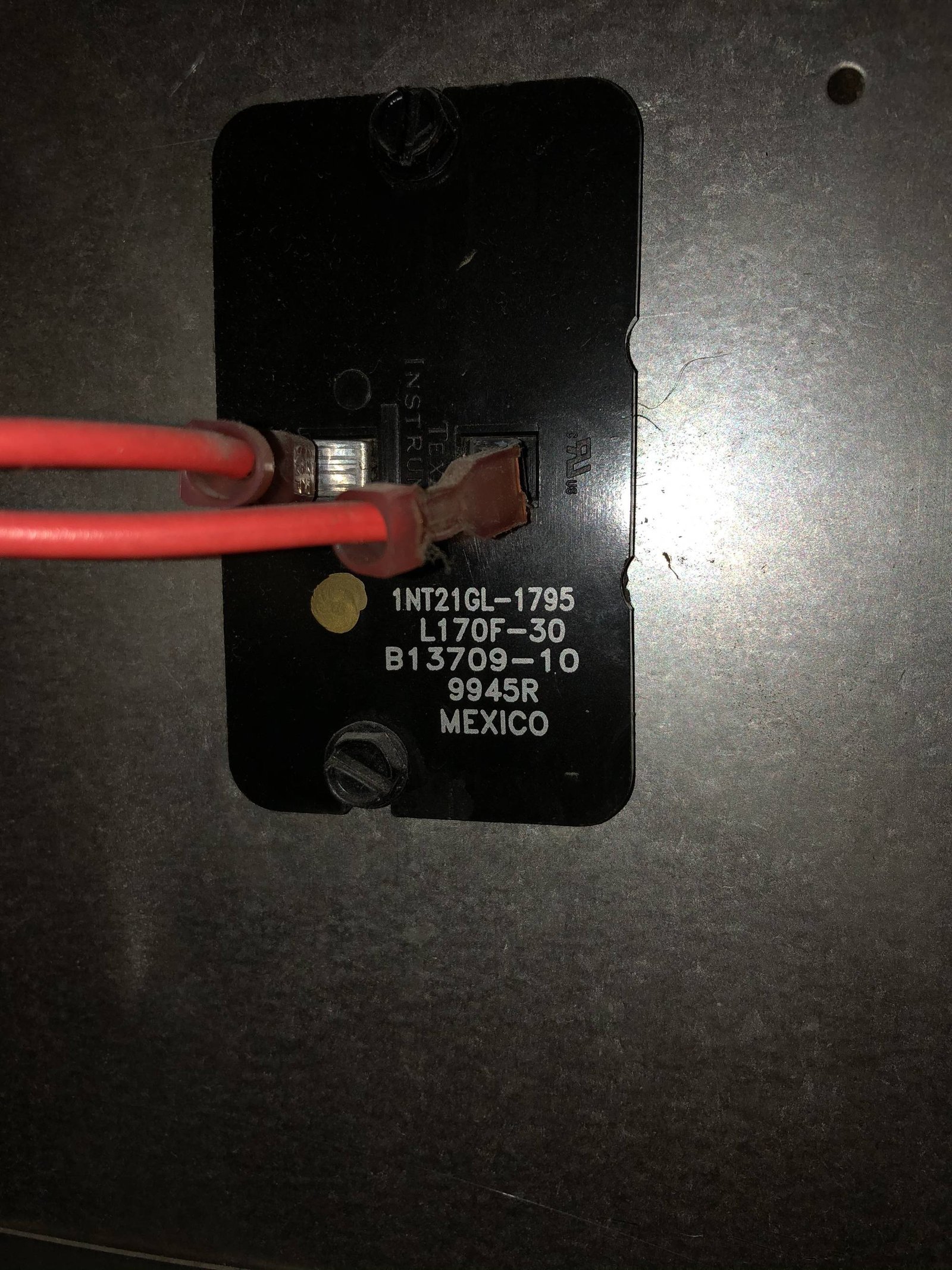A person troubleshooting a furnace limit switch by inspecting the internal wiring components.