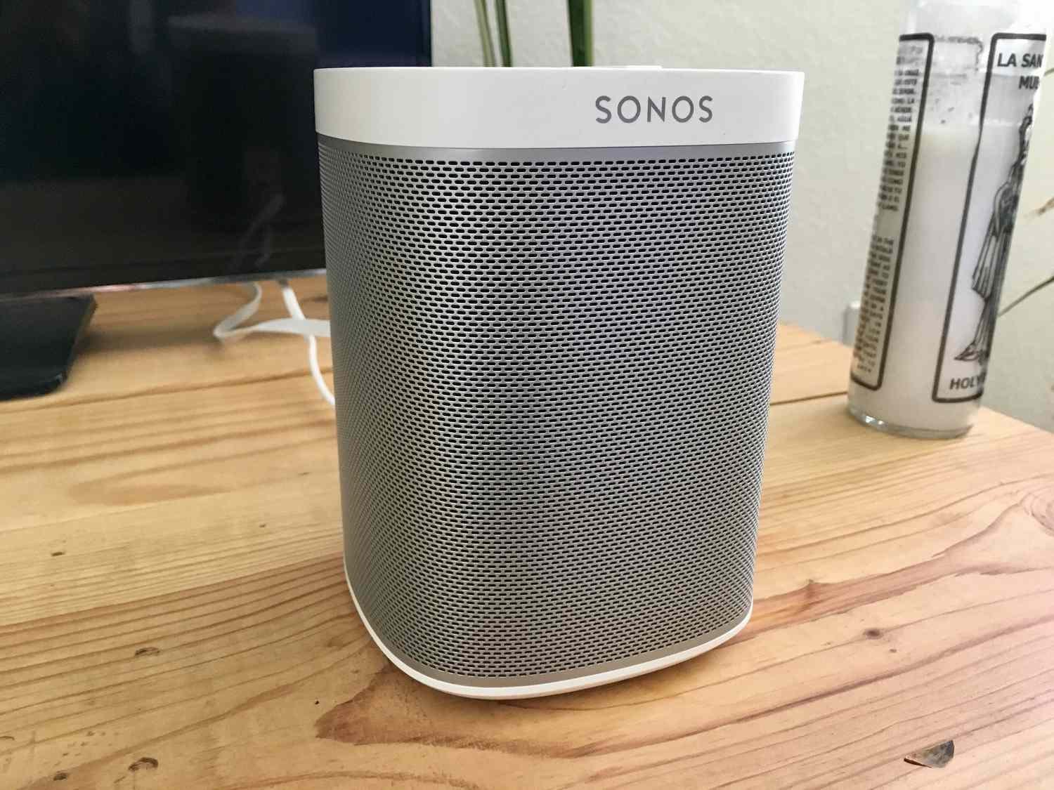 A green flashing light on the top panel of a Sonos Play 1 speaker.