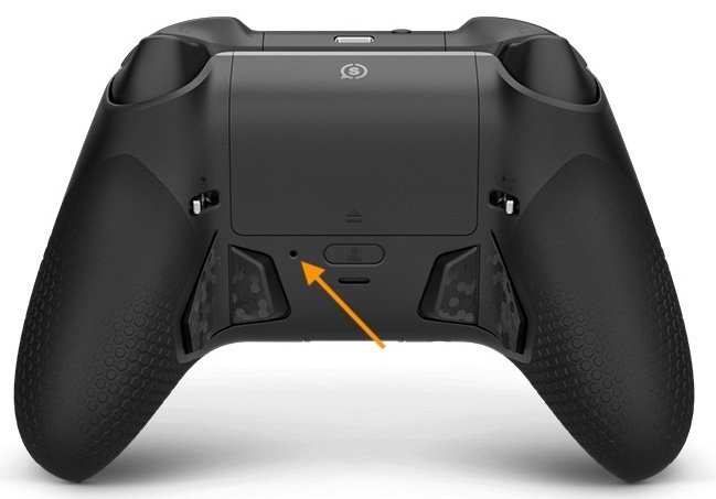 Hands removing batteries from the back of an Xbox controller for a reset.