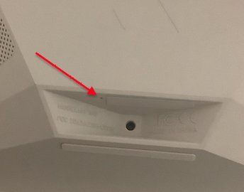 Using a small tool to press the reset button on an Aura frame.