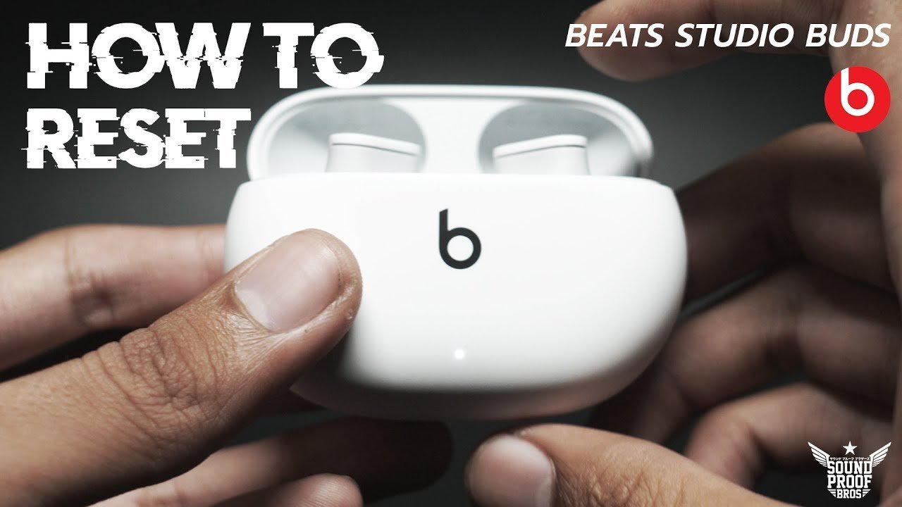 Essential items for resetting Beats Studio Buds laid out on a clean desk.