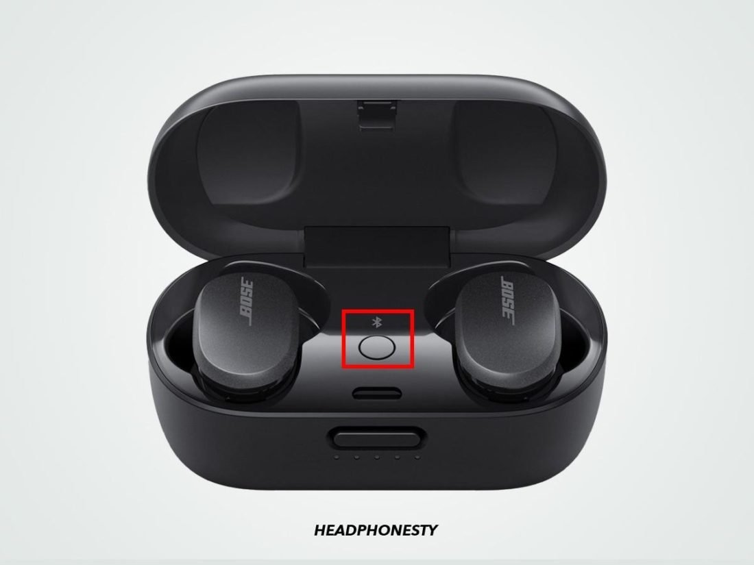 A smartphone stopwatch next to wireless earbuds during the time-sensitive reset process.