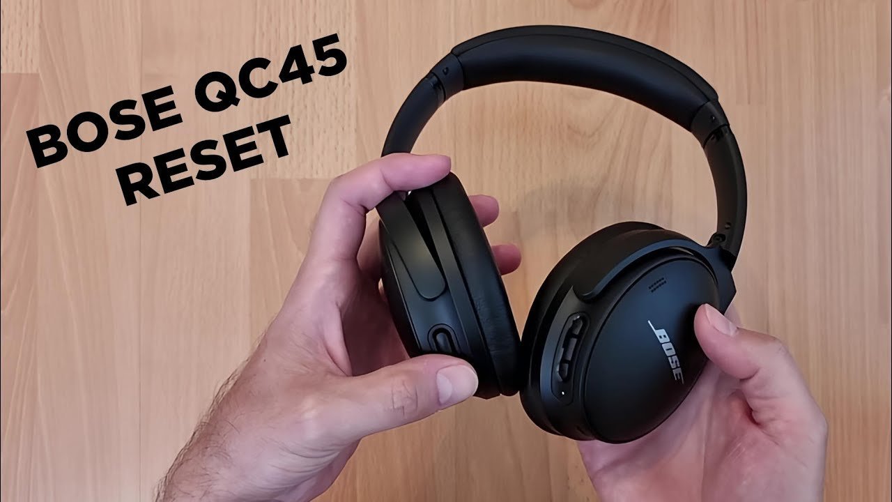 Essential tools for resetting Bose headphones including a charging cable and smartphone screen.