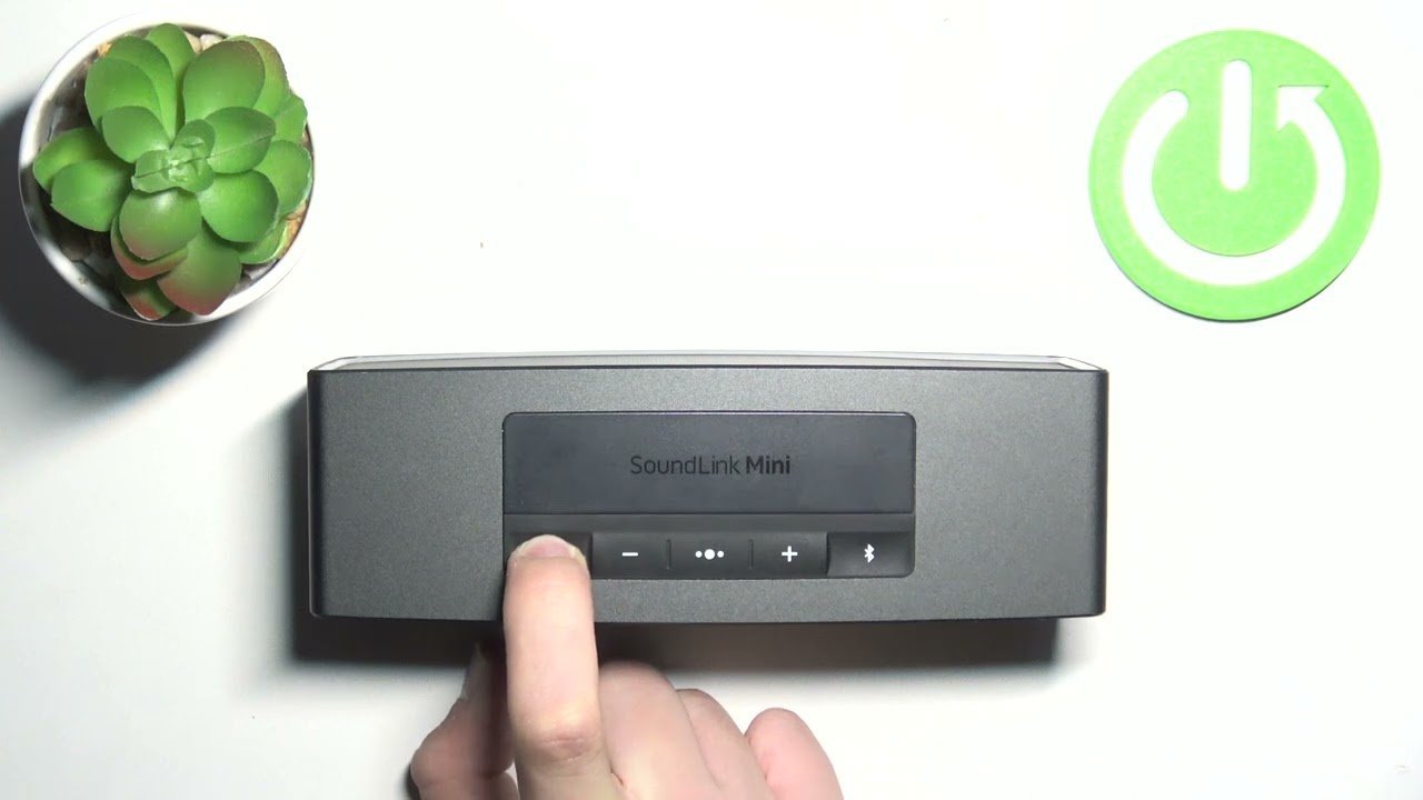Troubleshooting a wireless speaker connection while checking a smartphone for reset instructions.