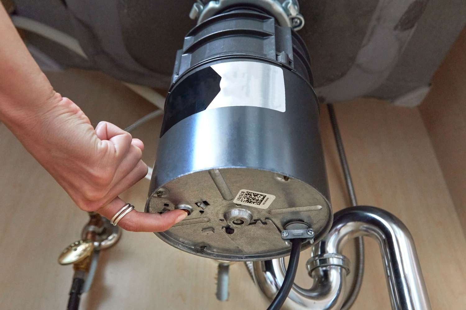 Essential tools like a flashlight, hex key, and tongs for repairing a garbage disposal.