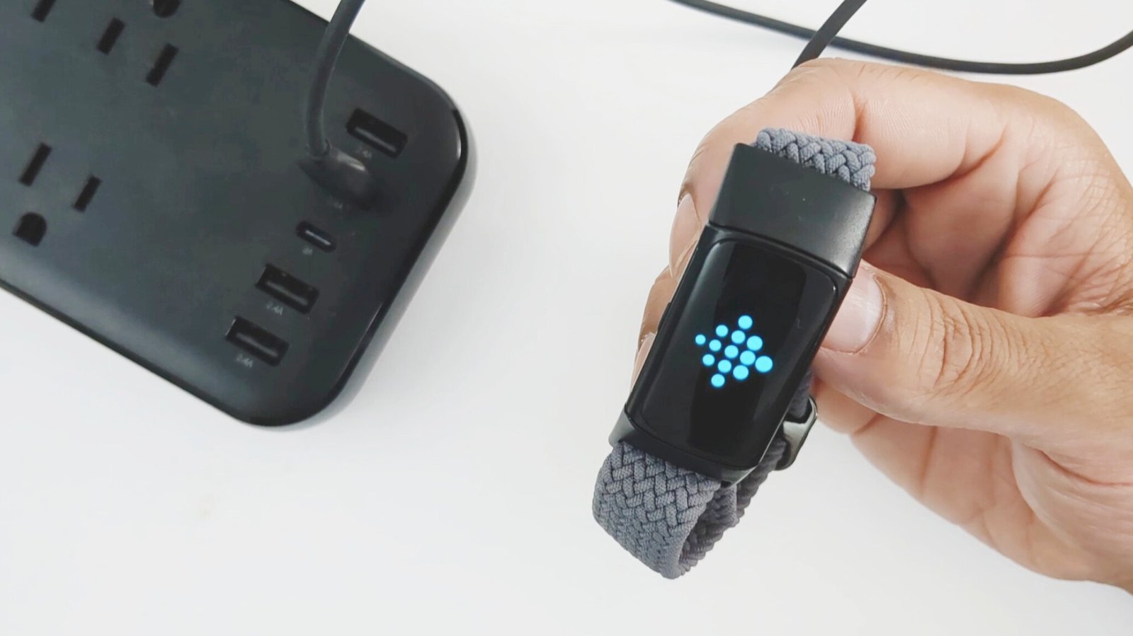 A finger swipes through the settings menu on a Fitbit Charge 6.