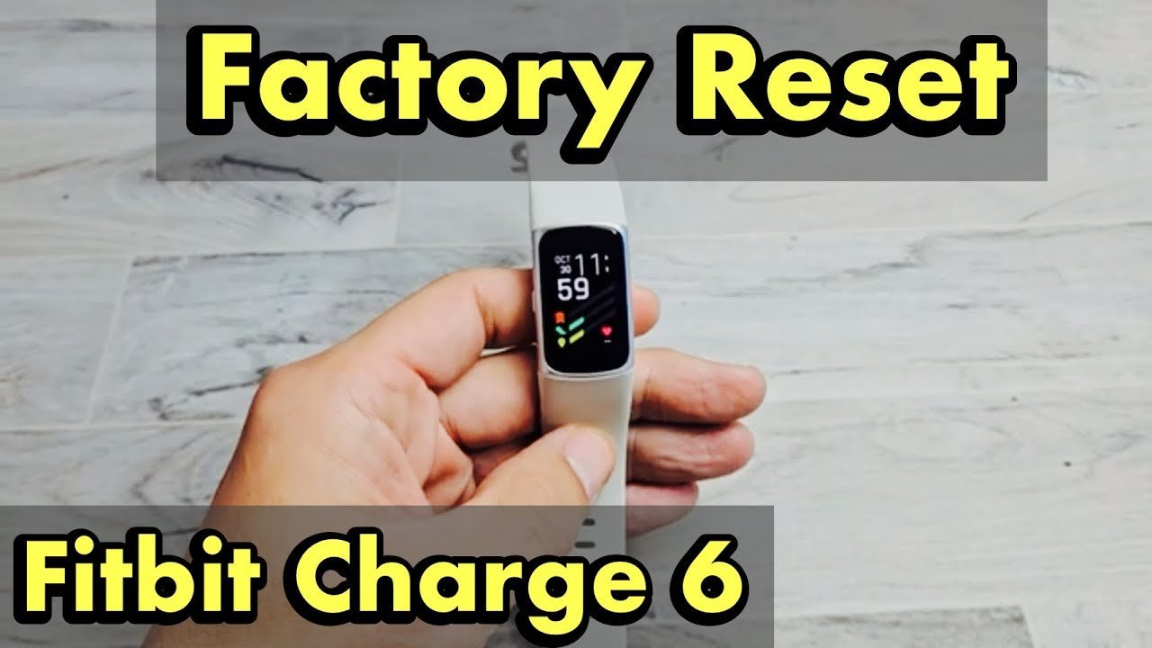 A Fitbit Charge 6 is carefully connected to its charging cable for syncing.