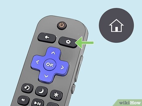 A remote control and a paperclip arranged on a table for resetting a Hisense TV.