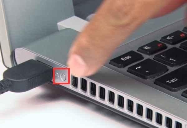 A metal paperclip positioned near the Novo button on a Lenovo IdeaPad laptop.