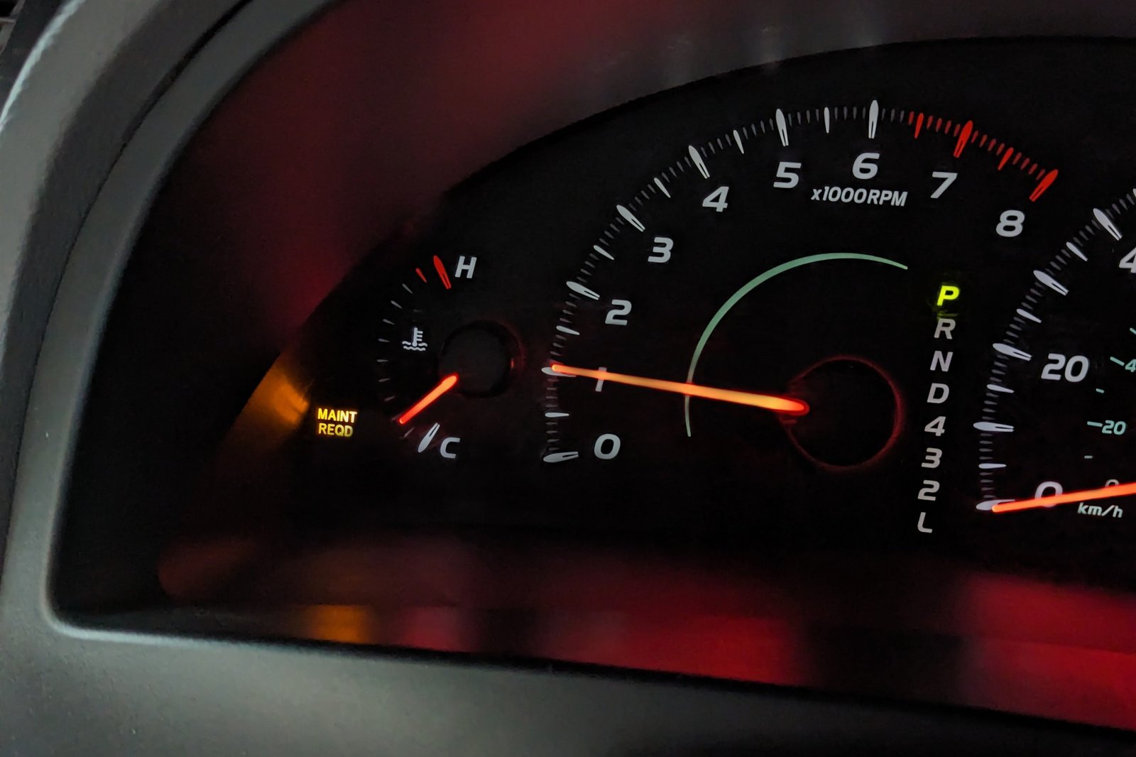 A glowing maintenance required light on a modern Toyota Camry instrument cluster dashboard.
