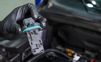 Essential tools for resetting a mass air flow sensor placed on a clean workbench.