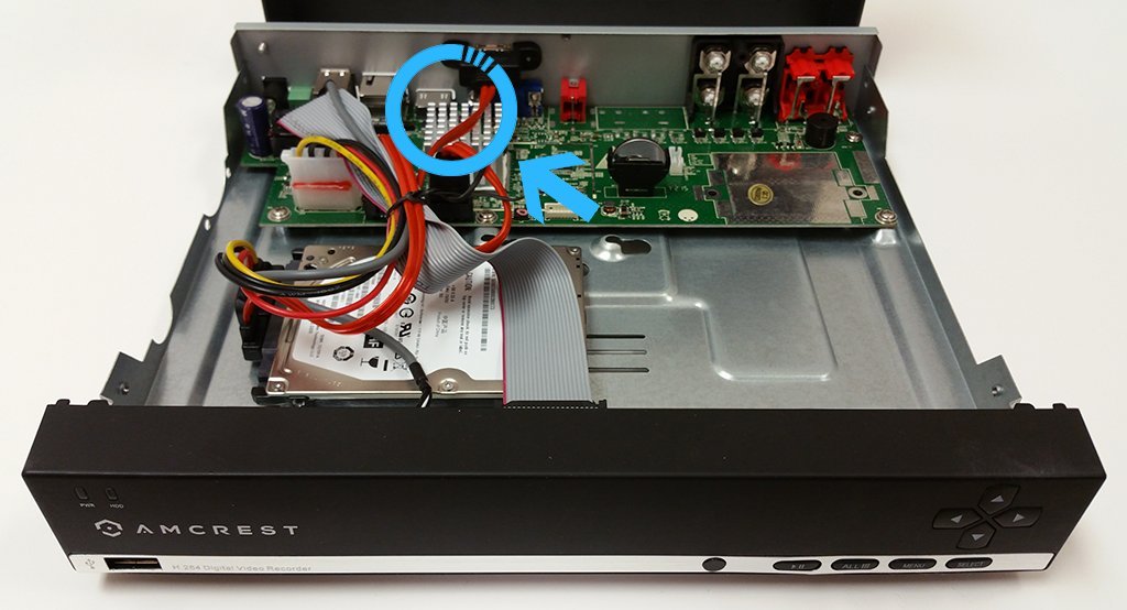 Using a paperclip to access the physical pinhole reset button on a DVR.