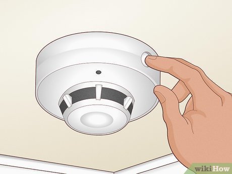 Essential tools for smoke detector maintenance laid out on a clean wooden surface.