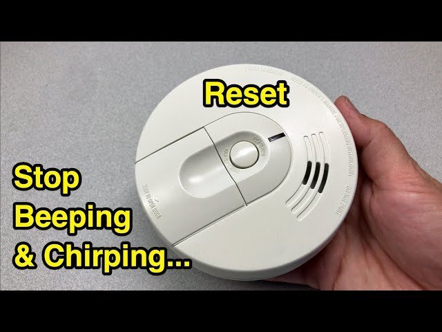 Inspecting the wiring harness of a hardwired smoke detector during a routine test.