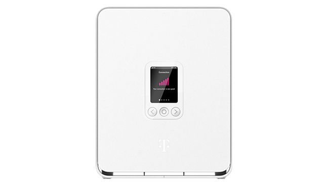 A tool held near the recessed reset button on a T-Mobile gateway device.