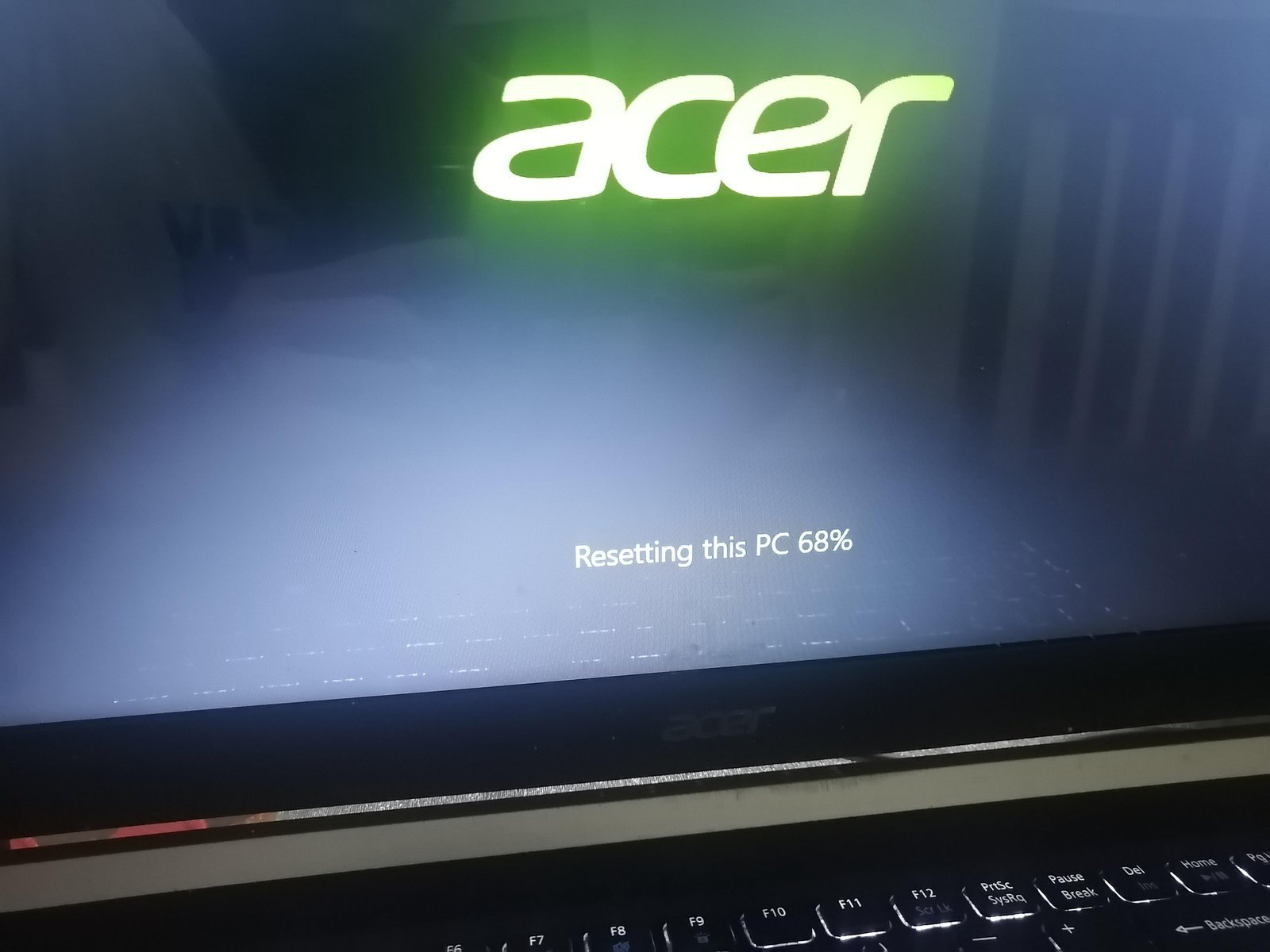 A hand pressing a power button to trigger the Windows recovery environment startup repair.
